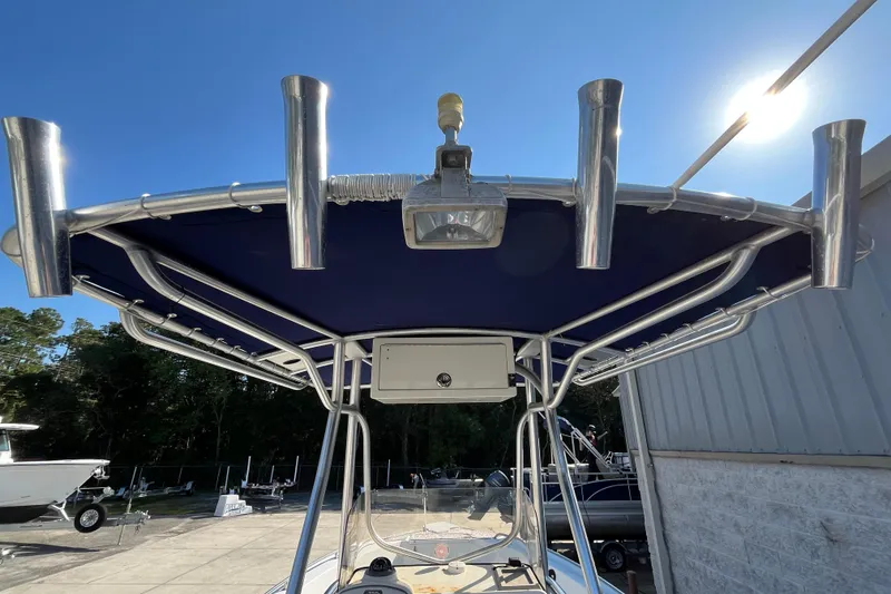 Slide: The Image of 2010 Sea Hunt Triton 220 boat with T-top and rod holders under clear blue sky. - 19