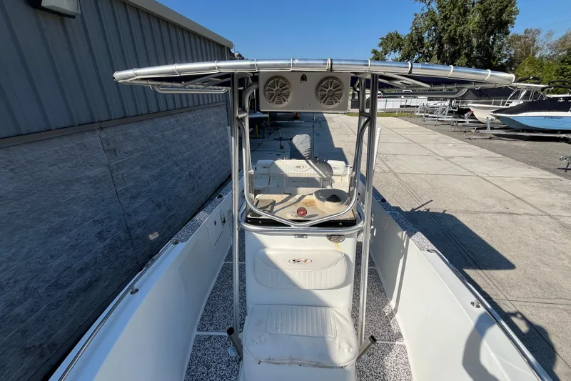 Slide: The Image of 2010 Sea Hunt Triton 220 boat with T-top and console, docked outdoors. - 22