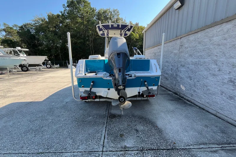 Slide: The Image of 2010 Sea Hunt Triton 220 boat with outboard motor, parked outdoors. - 23