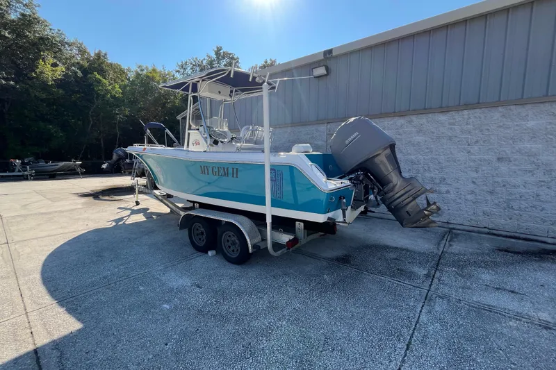 Slide: The Image of 2010 Sea Hunt Triton 220 boat on trailer, parked outdoors near a building. - 24