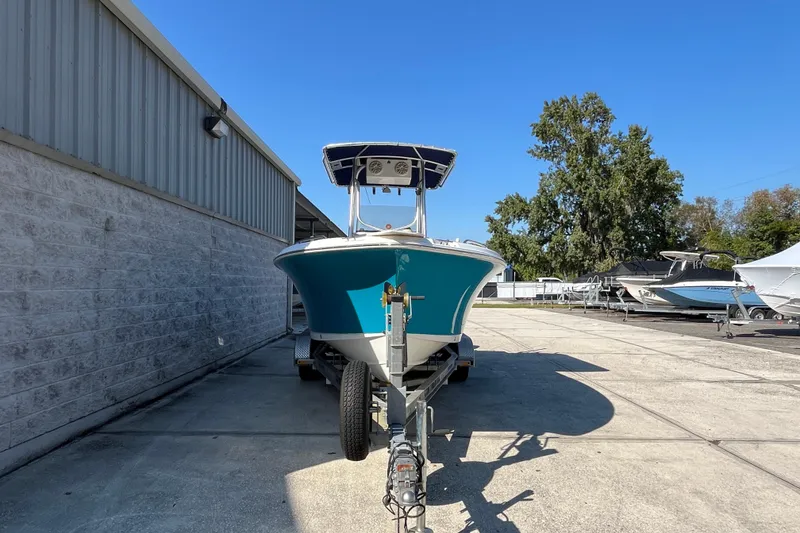 Slide: The Image of 2010 Sea Hunt Triton 220 boat on trailer, parked outdoors under clear blue sky. - 26