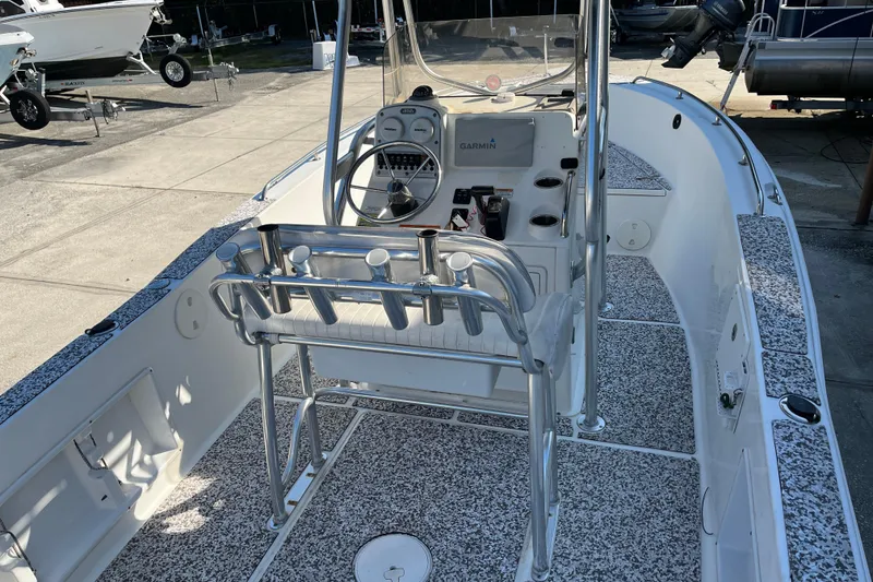 Slide: The Image of 2010 Sea Hunt Triton 220 boat interior with steering console and rod holders. - 4