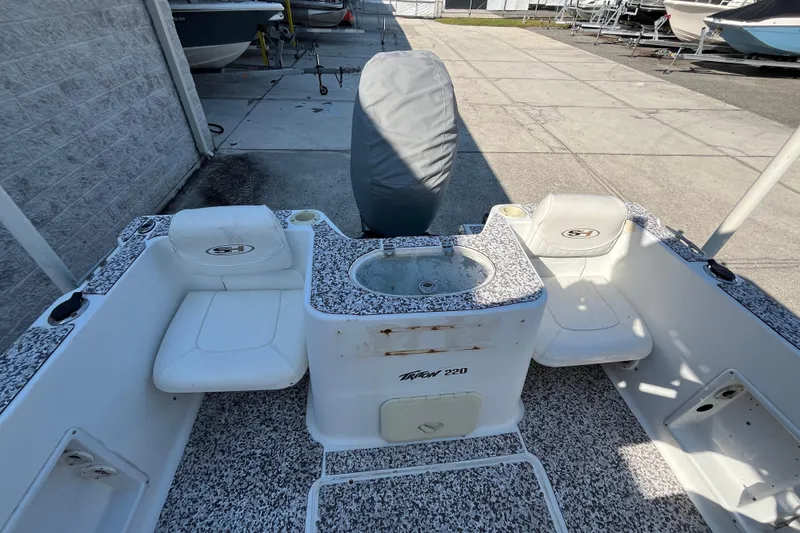 Slide: The Image of 2010 Sea Hunt Triton 220 boat interior with seating and covered engine. - 6