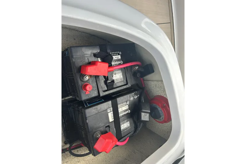 Slide: The Image of Battery compartment of 2022 Hurricane SunDeck Sport 185 OB boat with red cables. - 16