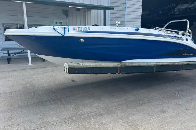 Slide: The Image of 2022 Hurricane SunDeck Sport 185 OB boat, blue hull, docked at marina. - 2