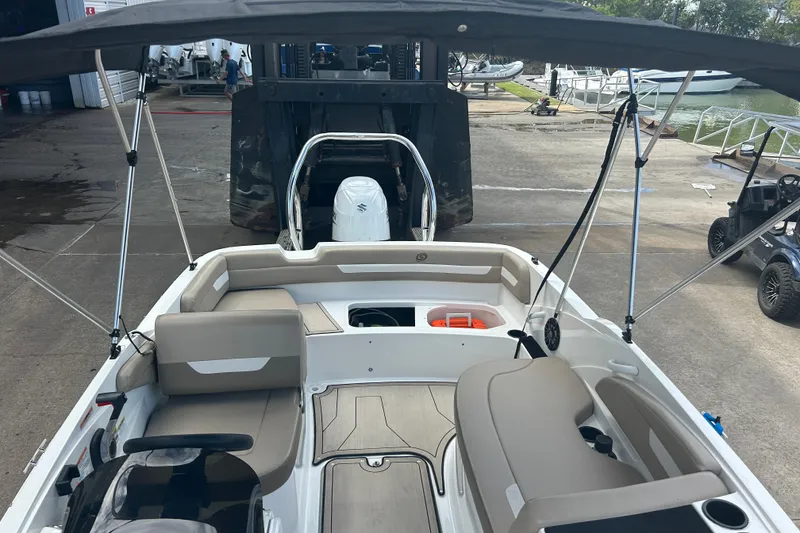 Slide: The Image of 2022 Hurricane SunDeck Sport 185 OB boat interior with seating and canopy, docked at marina. - 21