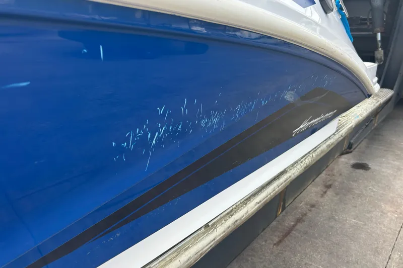 Slide: The Image of 2022 Hurricane SunDeck Sport 185 OB boat with visible scratches on blue hull. - 32