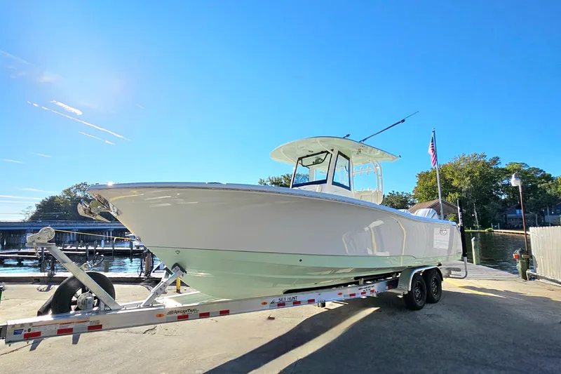 Slide: The Image of 2026 Sea Hunt Gamefish 30 Forward Seating boat on trailer, sunny day at marina. - 6
