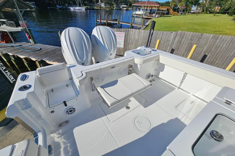 Slide: The Image of 2026 Sea Hunt Gamefish 30 boat with forward seating, docked by a serene waterfront. - 9