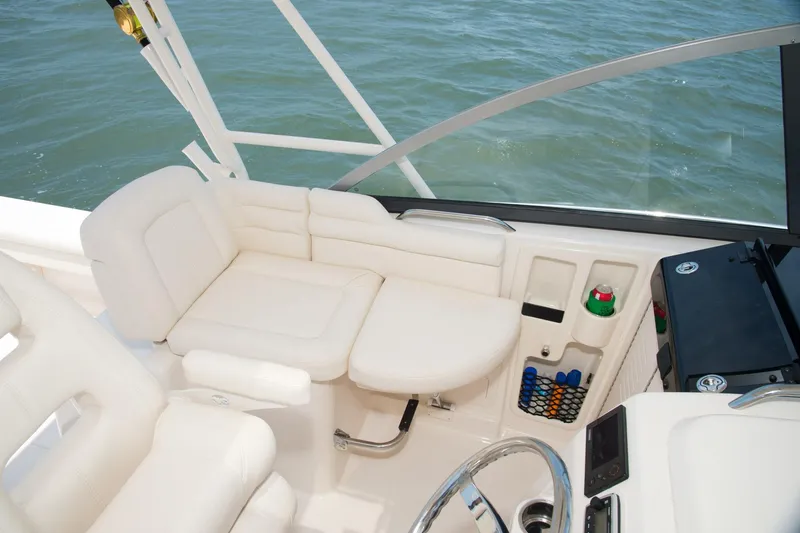 Slide: The Image of 2019 Grady-White Express 330 helm with navigation screens and controls, docked at marina. - 10