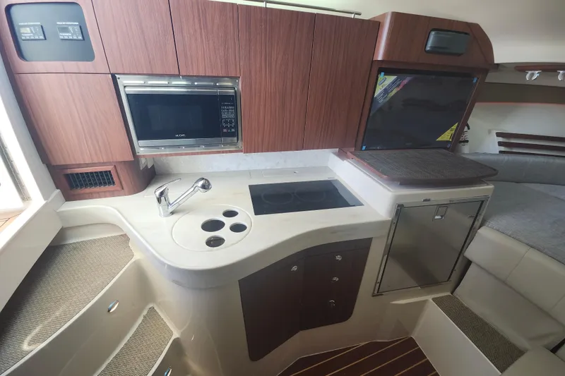 Slide: The Image of 2019 Grady-White Express 330 interior kitchen with microwave, sink, and stove. - 24