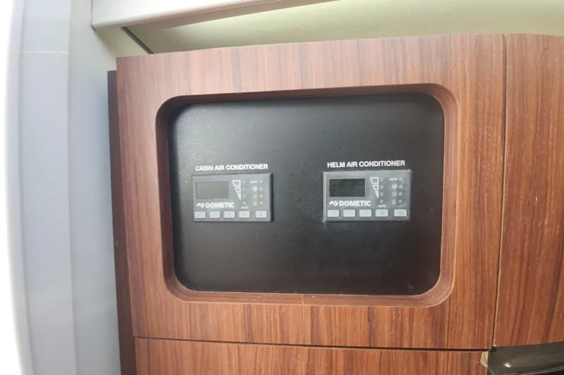 Slide: The Image of Control panel for cabin and helm air conditioners on a 2019 Grady-White Express 330 boat. - 28