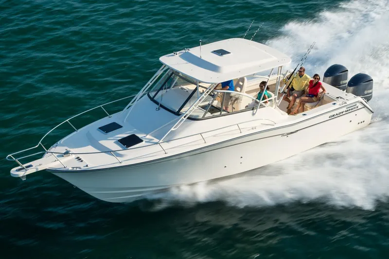 Slide: The Image of 2019 Grady-White Express 330 boat docked at marina, surrounded by other vessels. - 3