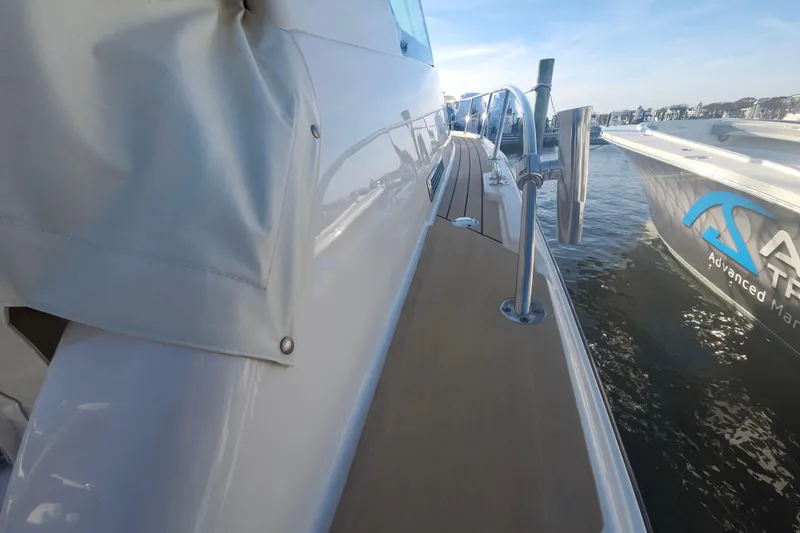Slide: The Image of 2019 Grady-White Express 330 boat docked, showcasing sleek design and side deck view. - 30