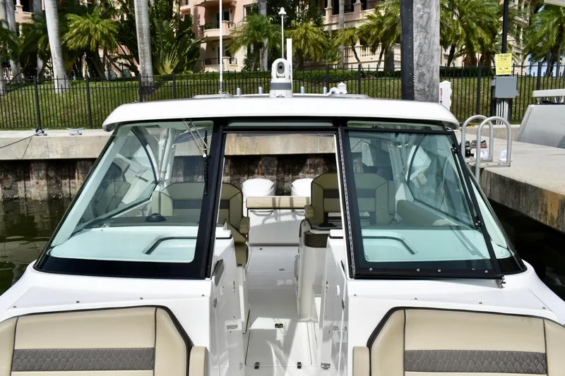 Slide: The Image of 2019 Pursuit DC 325 Dual Console boat docked, featuring spacious seating and modern design. - 15