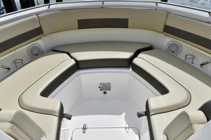 Slide: The Image of 2019 Pursuit DC 325 Dual Console boat interior with cushioned seating and speakers. - 16