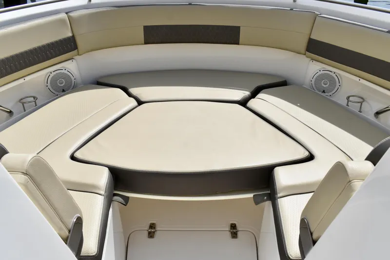 Slide: The Image of 2019 Pursuit DC 325 Dual Console boat interior with cushioned seating and speakers. - 17