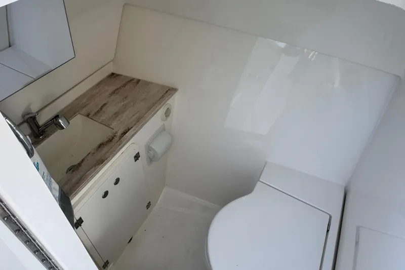 Slide: The Image of 2019 Pursuit DC 325 Dual Console boat bathroom with sink and toilet. - 19