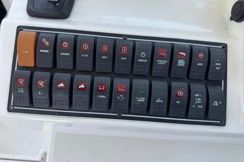 Slide: The Image of Control panel of a 2019 Pursuit DC 325 Dual Console boat with labeled switches. - 33