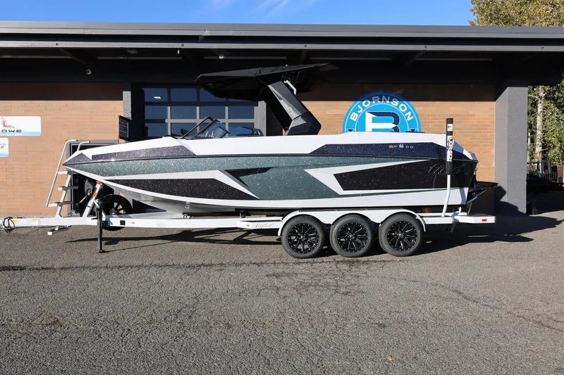 The Image of 2026 Tigé 24RZX boat on trailer, parked outside a building. - 1