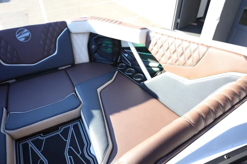 Slide: The Image of 2026 Tigé 24RZX boat interior with luxurious brown and gray seating, cup holders, and speaker. - 16