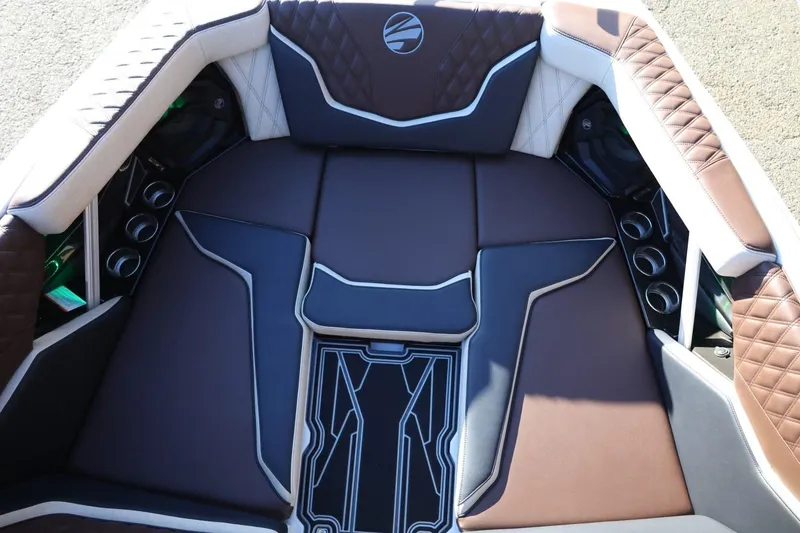 Slide: The Image of 2026 Tigé 24RZX boat interior with brown and white cushioned seating and cup holders. - 17