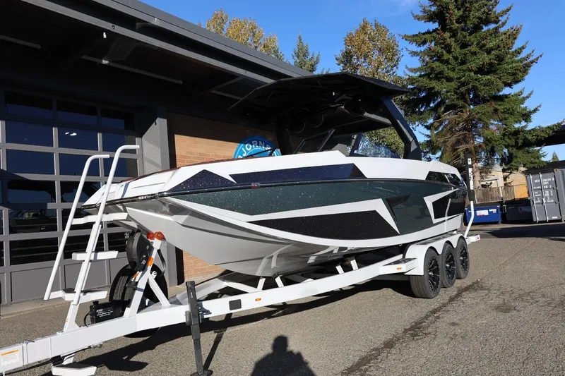 Slide: The Image of 2026 Tigé 24RZX boat on trailer, parked outdoors near a building. - 2