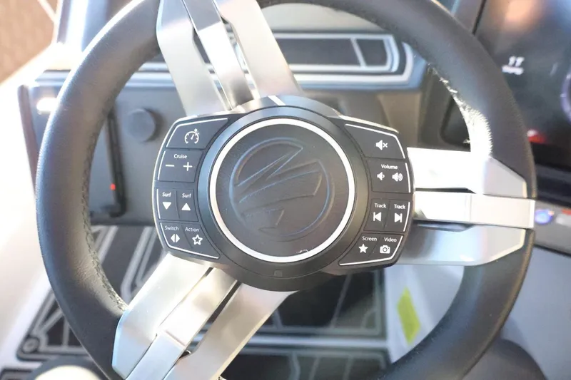 Slide: The Image of Steering wheel of 2026 Tigé 24RZX boat with integrated control buttons. - 24