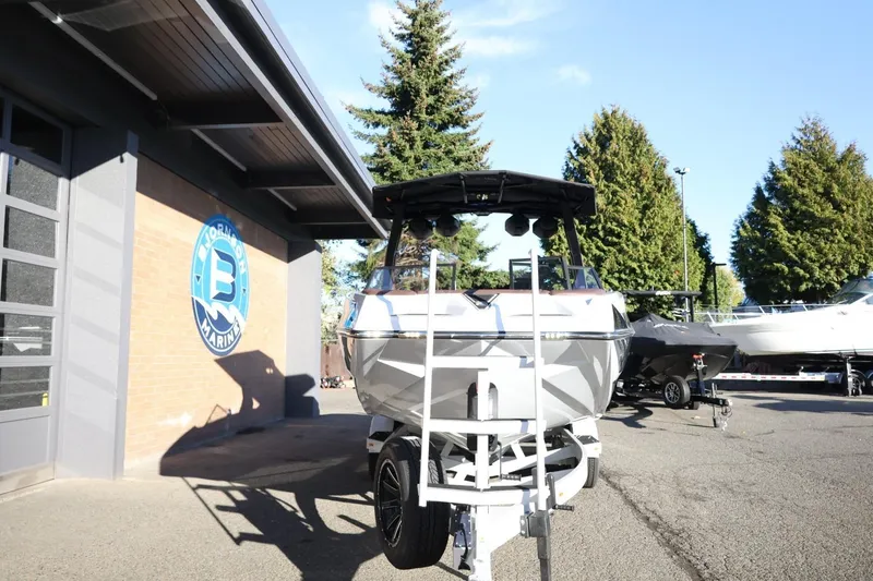 Slide: The Image of 2026 Tigé 24RZX boat on trailer outside marine dealership, sunny day. - 3