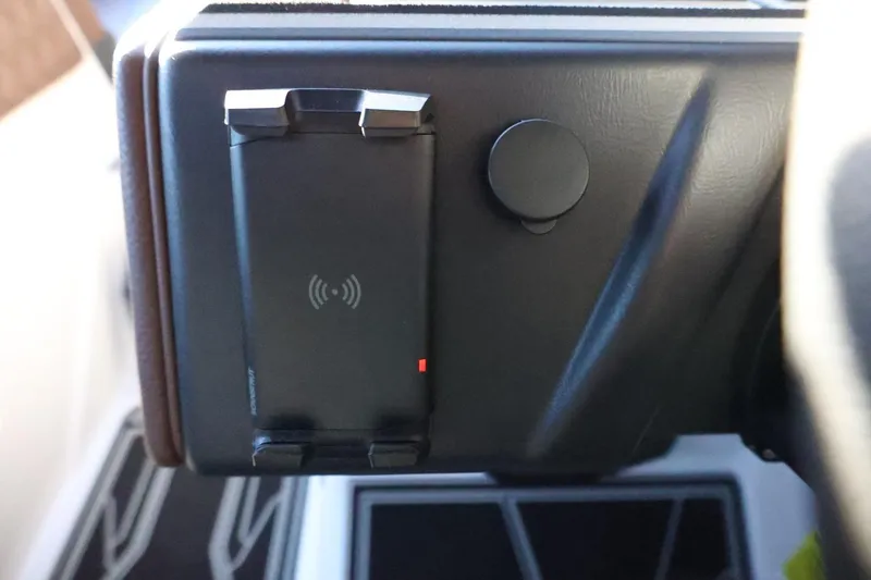 Slide: The Image of Dashboard of 2026 Tigé 24RZX featuring a wireless charging pad and control knob. - 32