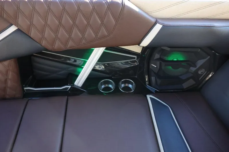 Slide: The Image of 2026 Tigé 24RZX interior with brown leather seats, cup holders, and green-lit speaker. - 41