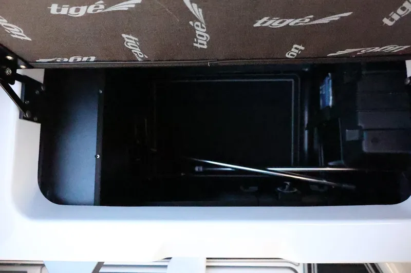 Slide: The Image of Storage compartment of 2026 Tigé 24RZX boat, featuring branded interior and mechanical components. - 45