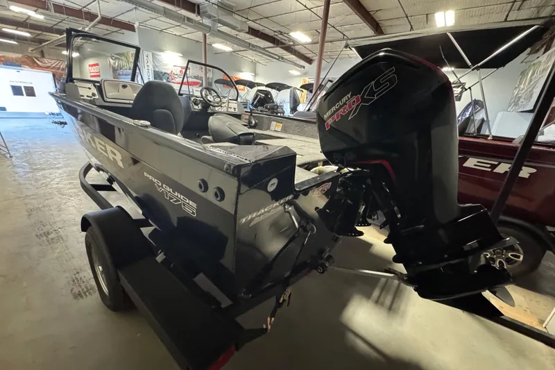 Slide: The Image of 2026 Tracker Pro Guide V-175 Combo boat with Mercury Pro XS engine in showroom. - 3