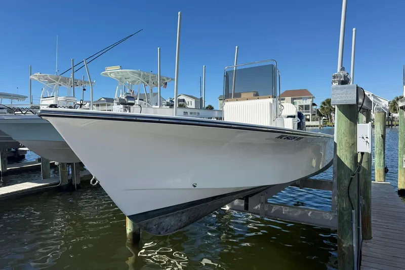 Slide: The Image of 2023 C-Hawk 23 Center Console boat docked at marina under clear blue sky. - 1