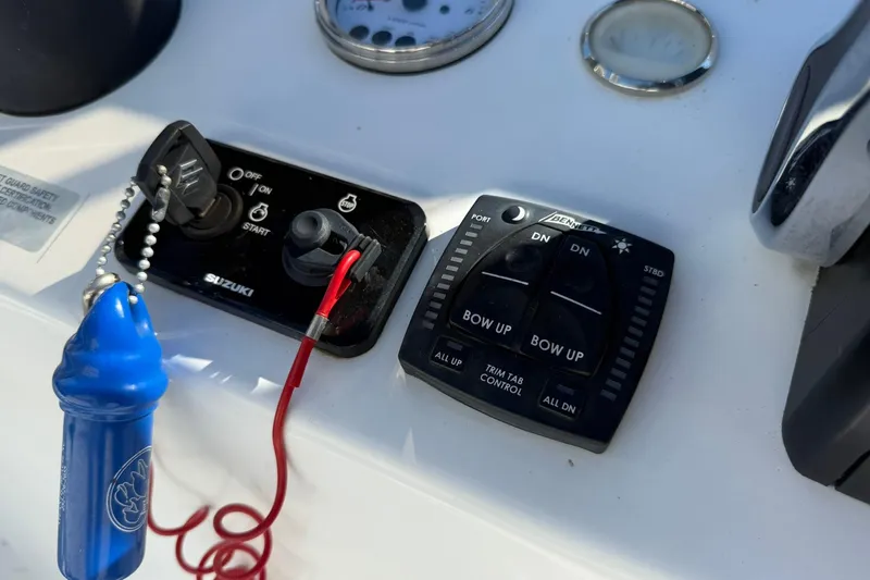 Slide: The Image of Control panel of 2023 C-Hawk 23 Center Console boat with Suzuki ignition and trim tab controls. - 15