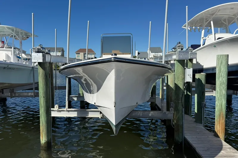 Slide: The Image of 2023 C-Hawk 23 Center Console boat docked at marina, clear blue sky. - 2