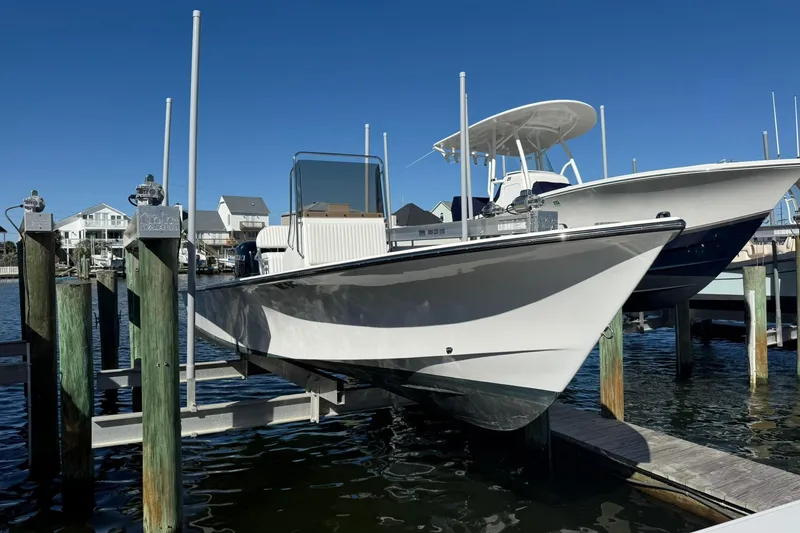 Slide: The Image of 2023 C-Hawk 23 Center Console boat docked at marina under clear blue sky. - 3