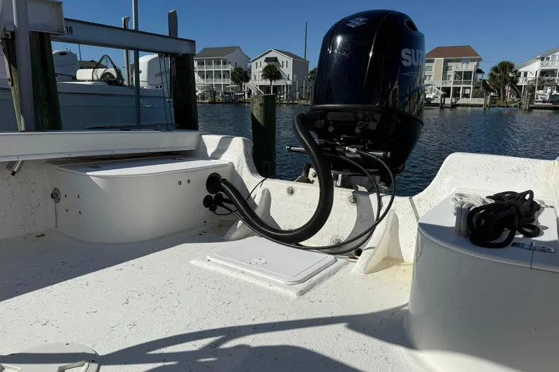 Slide: The Image of 2023 C-Hawk 23 Center Console boat with outboard motor, docked near waterfront homes. - 8