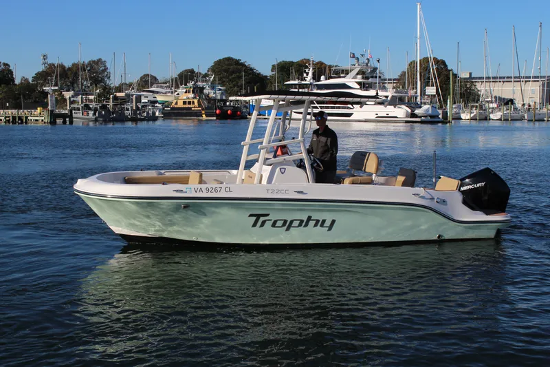 Slide: The Image of 2024 Bayliner CC22 Trophy boat on water, with marina background. - 1