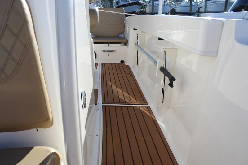 Slide: The Image of 2024 Bayliner CC22 boat interior with teak flooring and beige seating. - 14