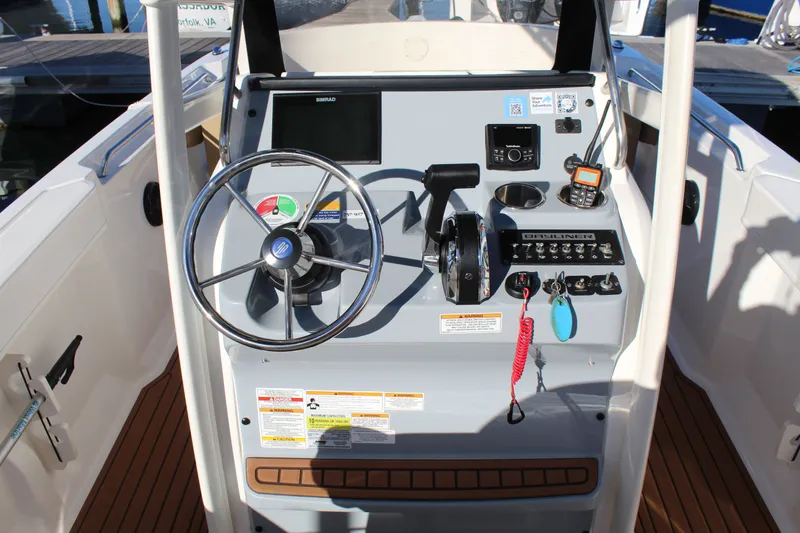 Slide: The Image of 2024 Bayliner CC22 boat dashboard with steering wheel and control panel. - 16