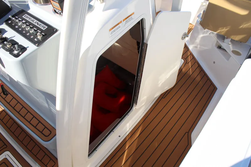 Slide: The Image of 2024 Bayliner CC22 boat interior with open storage compartment and control panel. - 18