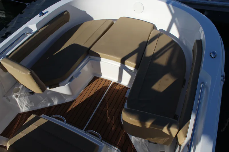 Slide: The Image of 2024 Bayliner CC22 boat interior with cushioned seating and wooden flooring. - 9