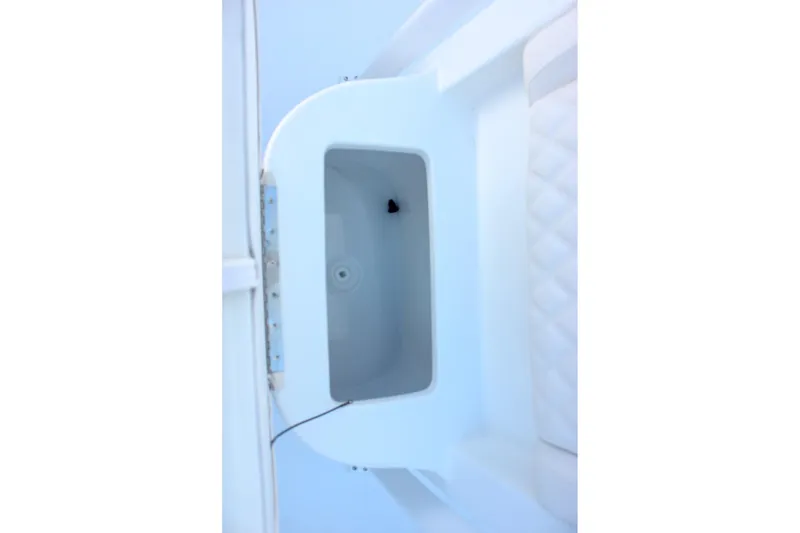 Slide: The Image of 2026 Sea Hunt Ultra 229 boat storage compartment with white interior and quilted seat detail. - 10