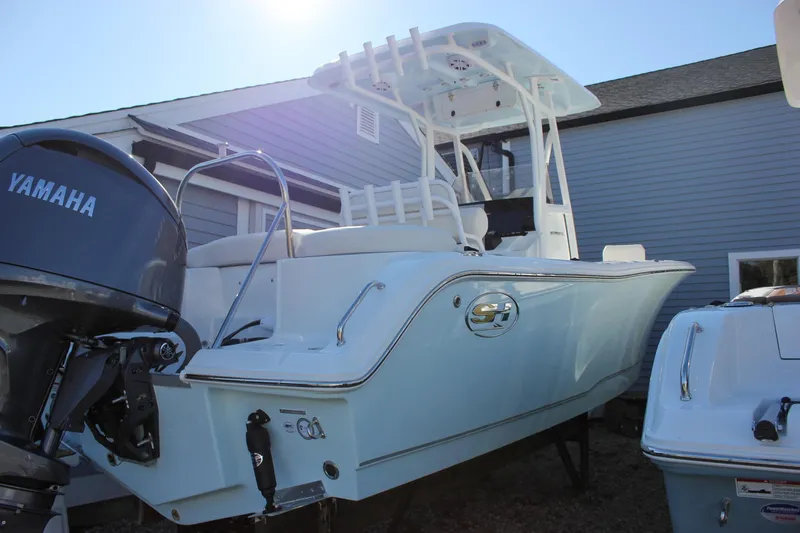 Slide: The Image of 2026 Sea Hunt Ultra 229 boat with Yamaha engine, parked outdoors. - 12