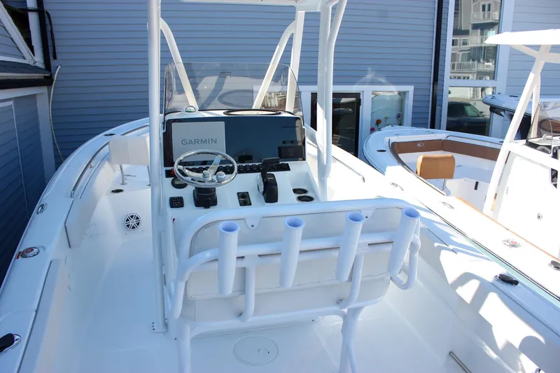 Slide: The Image of 2026 Sea Hunt Ultra 229 boat interior with Garmin navigation system and rod holders. - 14