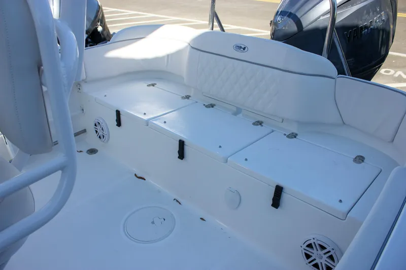 Slide: The Image of 2026 Sea Hunt Ultra 229 boat interior with white seating and storage compartments. - 16