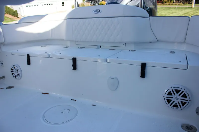 Slide: The Image of 2026 Sea Hunt Ultra 229 boat interior with white seating and storage compartments. - 18