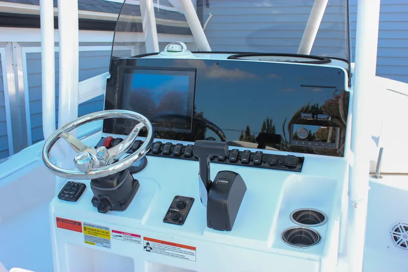 Slide: The Image of 2026 Sea Hunt Ultra 229 boat dashboard with steering wheel and control panel. - 2