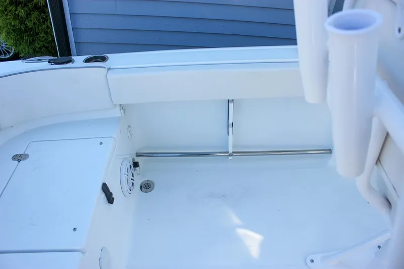 Slide: The Image of 2026 Sea Hunt Ultra 229 boat interior with rod holders and storage compartment. - 22